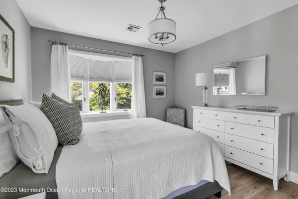 a bedroom with two beds and a painting on the wall