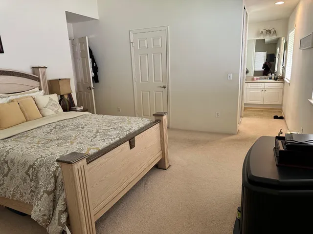 a spacious bedroom with a bed and a flat screen tv