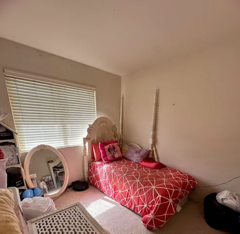 a bedroom with a bed and a window