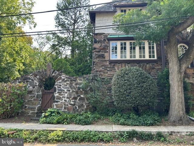Charming stone facade with lush greenery.