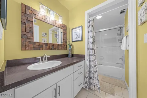 a bathroom with a granite countertop sink a mirror a vanity and shower