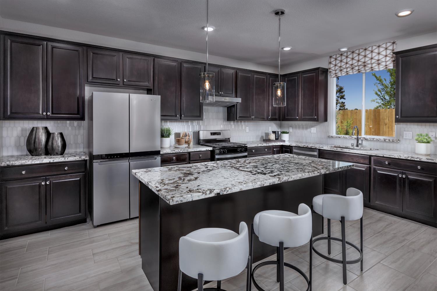 4553 Griffith Avenue Clovis, CA 93619 - Photo 7 of 10 a kitchen with kitchen island granite countertop a sink and a refrigerator