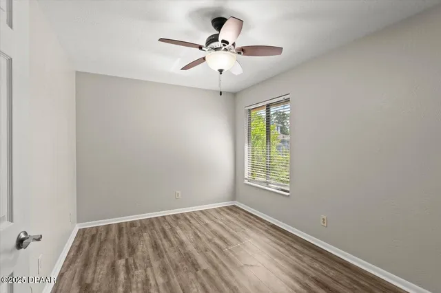 an empty room with a window and a ceiling fan