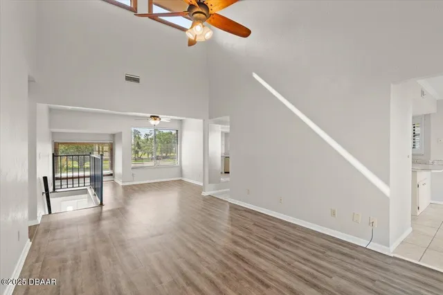 a view of a livingroom with wooden floor and a ceiling fan