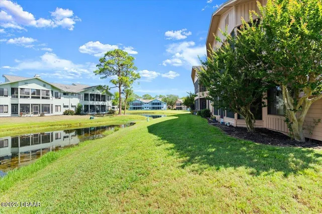 a view of a house with a big yard and large trees