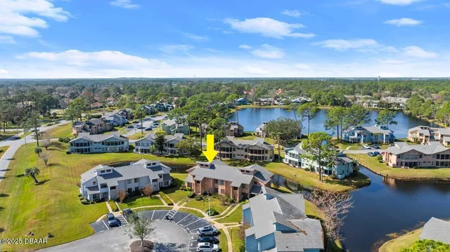 an aerial view of a city with lots of residential buildings ocean and mountain view in back