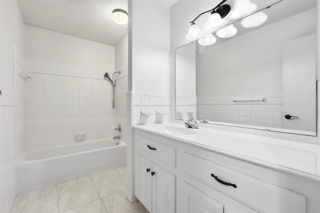 a bathroom with a tub sink and mirror