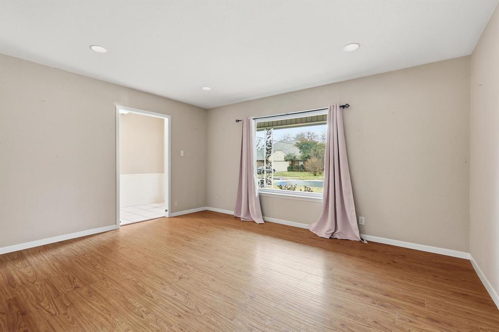 324 Moore Creek Road Hurst, TX 76053 - Photo 5 of 22 a view of an empty room with wooden floor and a window