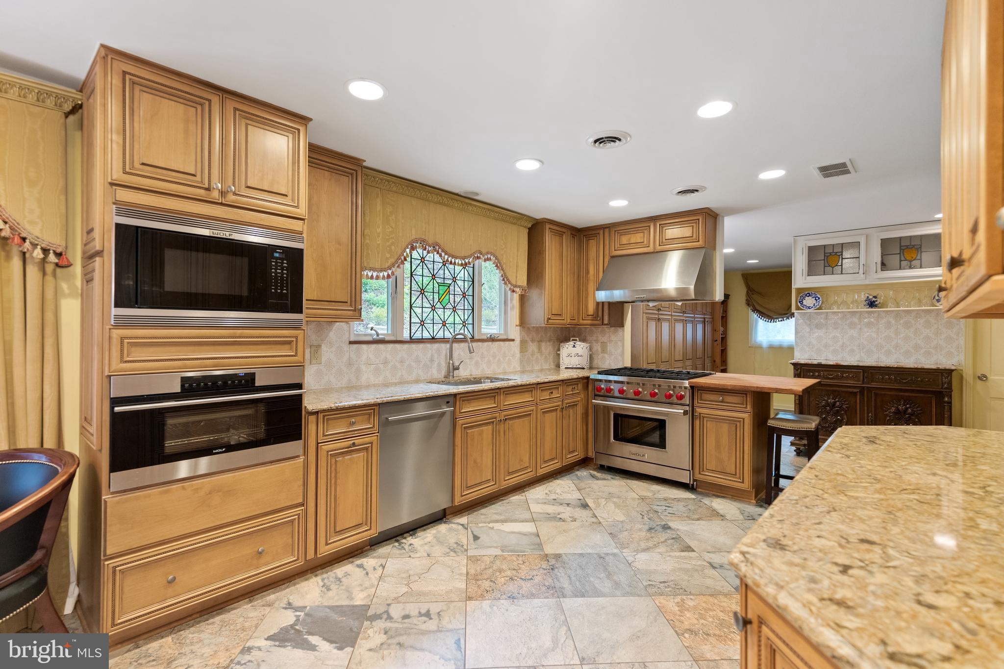 8751 Brook Road McLean, VA 22102 - Photo 18 of 103 a kitchen with stainless steel appliances kitchen island granite countertop a stove top oven and sink