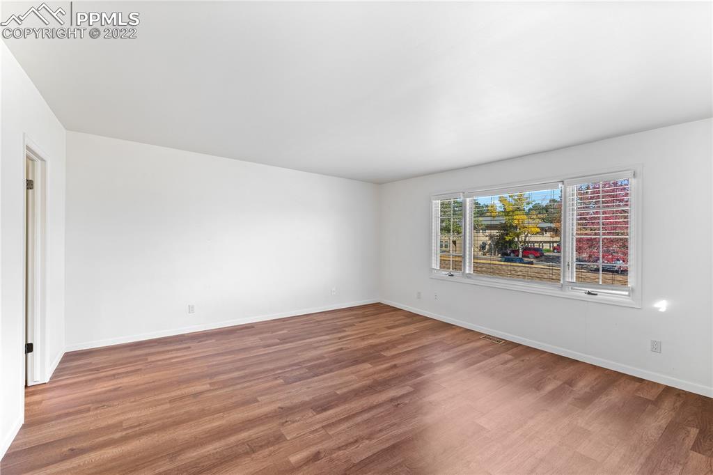 3105 Broadmoor Valley Road, Unit D Colorado Springs, CO 80906 - Photo 15 of 27 an empty room with wooden floor and windows