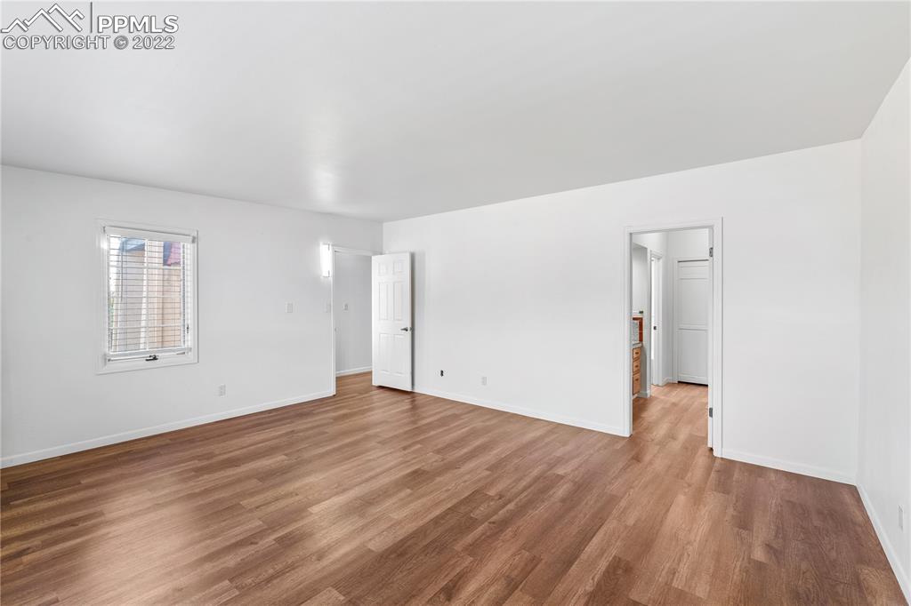 3105 Broadmoor Valley Road, Unit D Colorado Springs, CO 80906 - Photo 16 of 27 an empty room with wooden floor and windows
