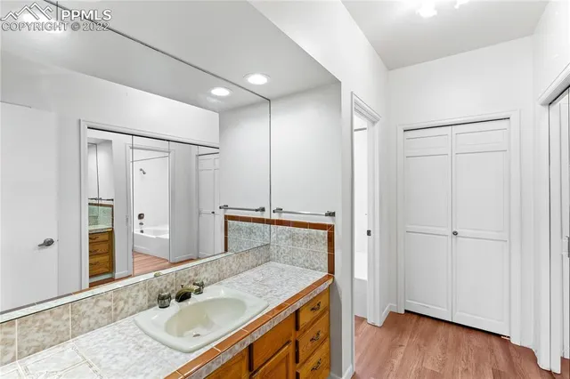 a bathroom with a granite countertop sink a mirror and shower