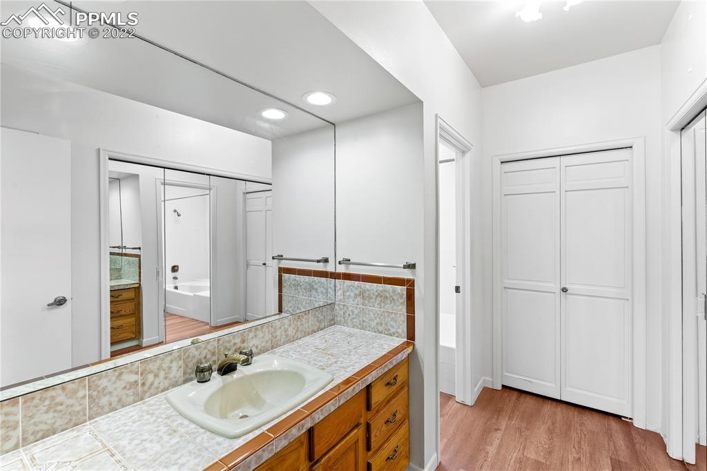 3105 Broadmoor Valley Road, Unit D Colorado Springs, CO 80906 - Photo 17 of 27 a bathroom with a granite countertop sink a mirror and shower