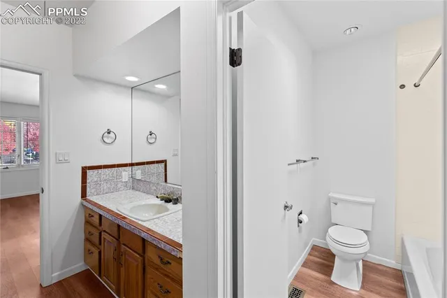 a bathroom with a granite countertop sink toilet and shower