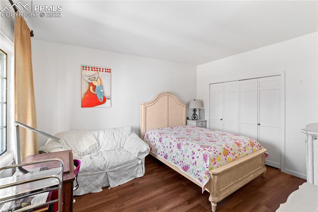 3105 Broadmoor Valley Road, Unit D Colorado Springs, CO 80906 - Photo 19 of 27 a bedroom with a bed and a painting on the wall