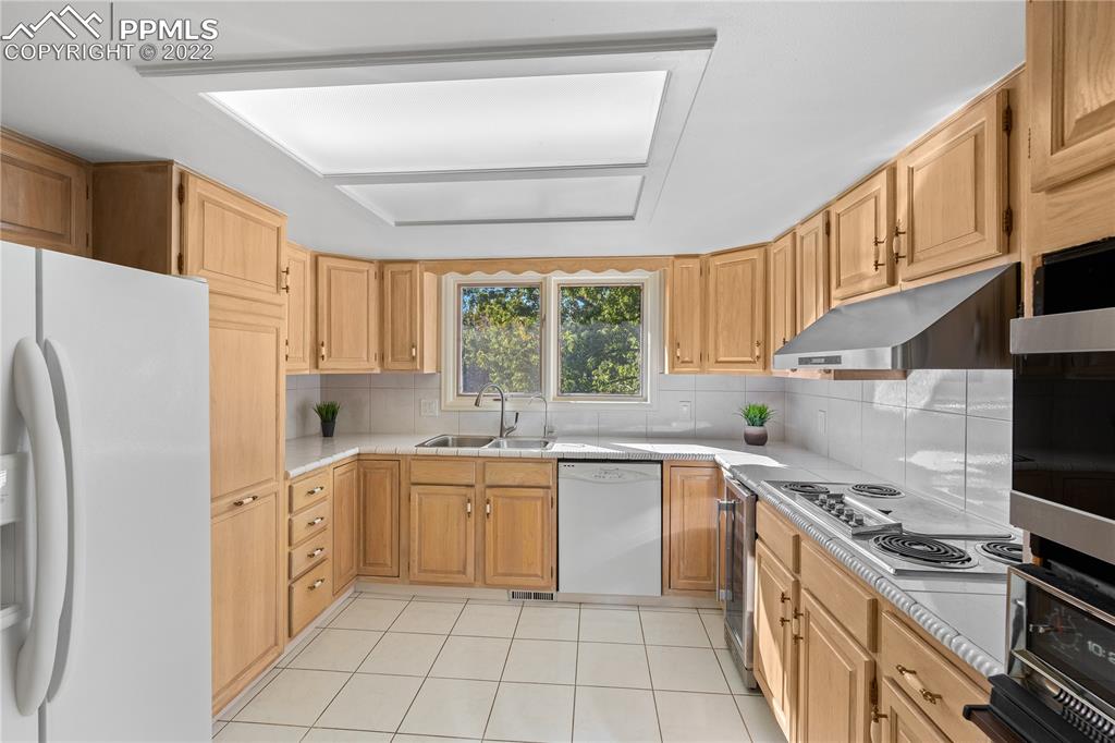 3105 Broadmoor Valley Road, Unit D Colorado Springs, CO 80906 - Photo 6 of 27 a kitchen with white cabinets and white appliances