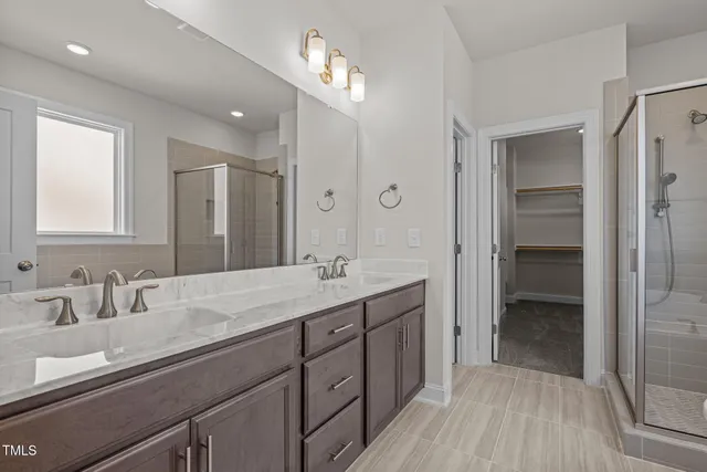 a bathroom with a double vanity sink a mirror and a shower
