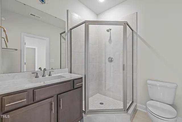 a bathroom with a shower sink vanity and toilet
