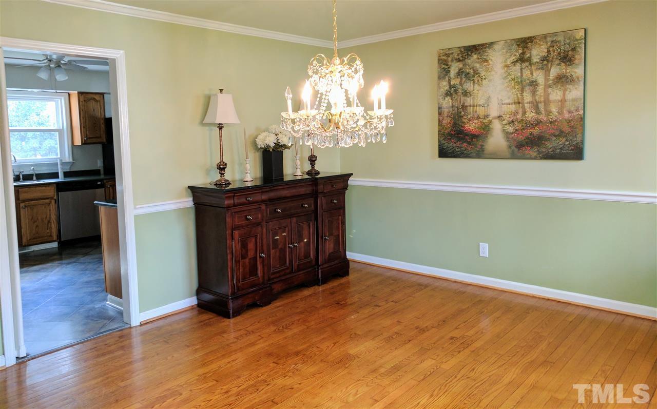 1004 Wofford Lane Raleigh, NC 27609 - Photo 5 of 13 a room with a chandelier and wooden floor