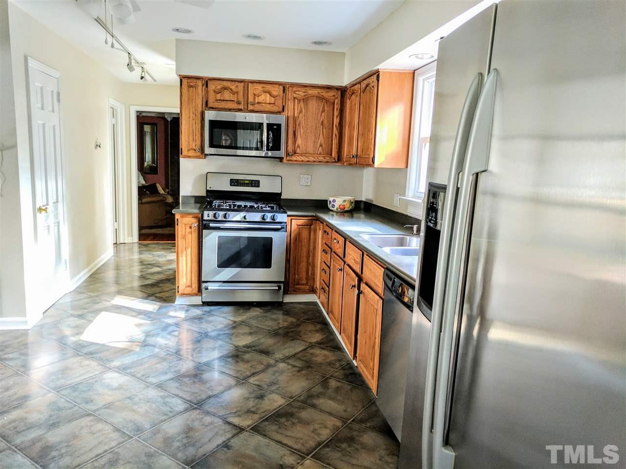 1004 Wofford Lane Raleigh, NC 27609 - Photo 7 of 13 a kitchen with granite countertop a refrigerator and a stove top oven