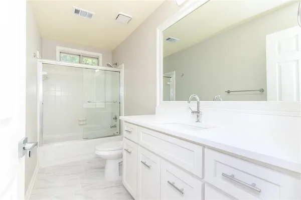 a bathroom with a sink a toilet and shower