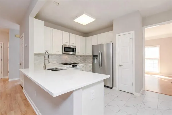 a kitchen with a refrigerator a stove a sink and a microwave