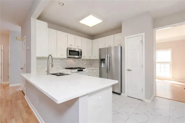 a kitchen with a refrigerator a stove a sink and a microwave