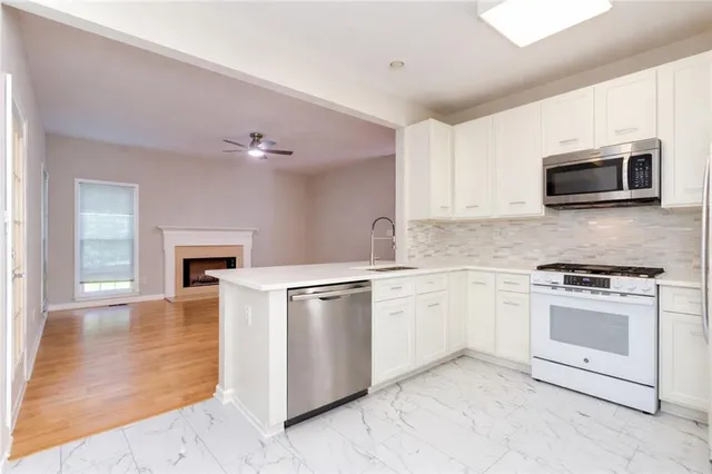 a kitchen with granite countertop a stove top oven microwave and cabinets