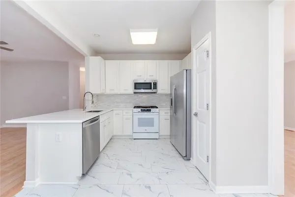 a kitchen with stainless steel appliances granite countertop a refrigerator and a stove