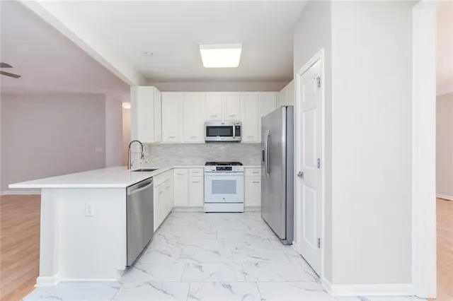 a kitchen with stainless steel appliances granite countertop a refrigerator and a stove