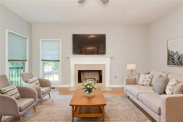 a living room with furniture a flat screen tv and a fireplace