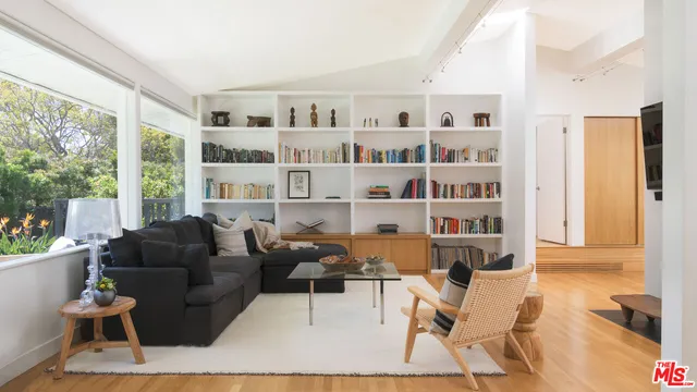 a living room with furniture and a book shelf