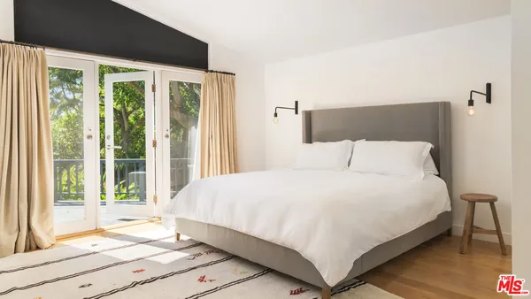 a large bed sitting in a bedroom next to a window