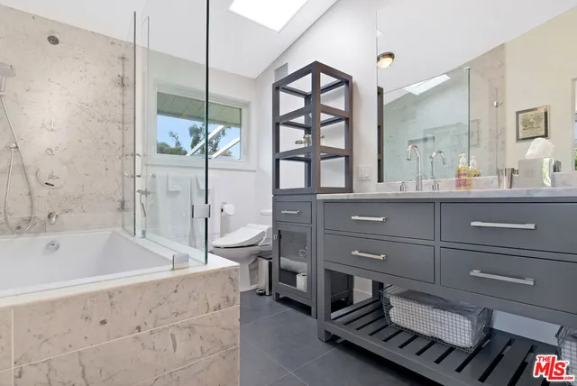 a bathroom with a bathtub sink and mirror