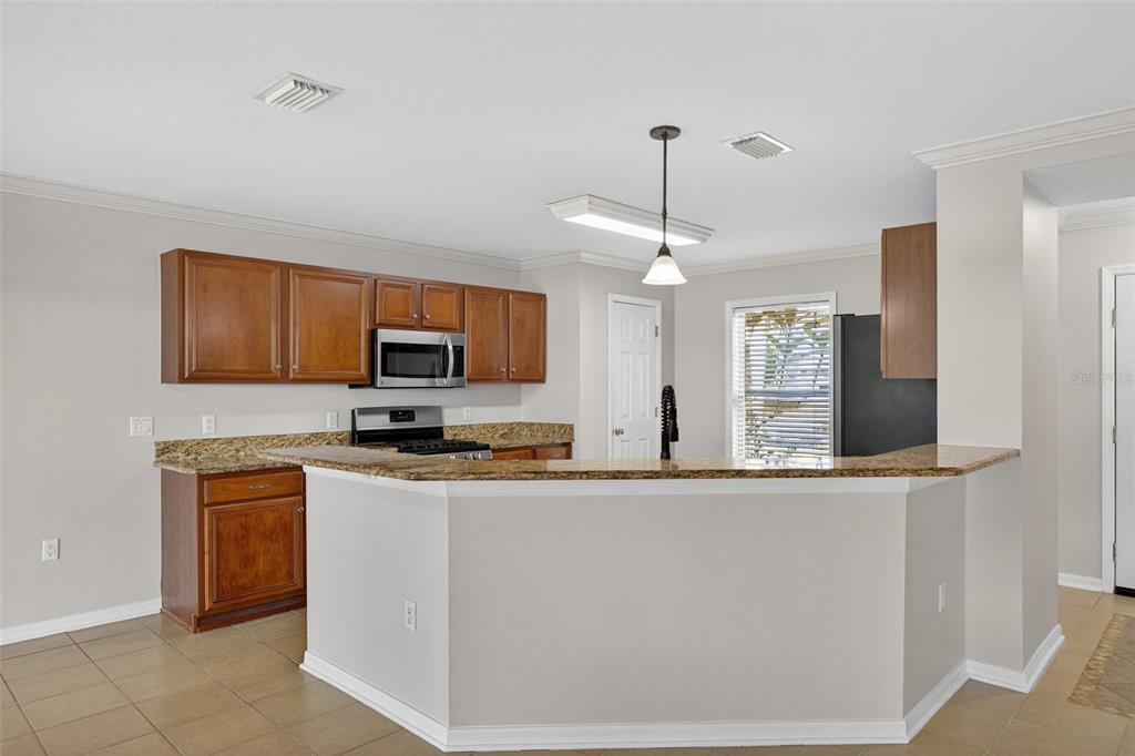 6611 Gates Pointe Way Riverview, FL 33578 - Photo 11 of 55 a kitchen with stainless steel appliances granite countertop a sink a stove top oven a counter space and cabinets