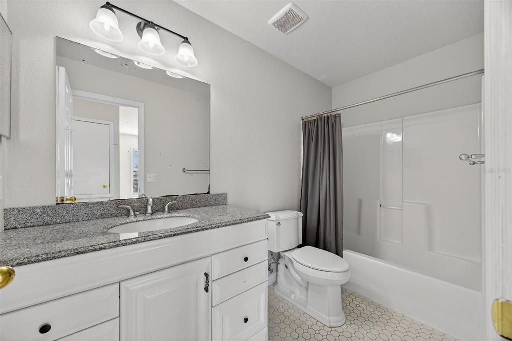6611 Gates Pointe Way Riverview, FL 33578 - Photo 23 of 55 a bathroom with a granite countertop sink toilet a large mirror a vanity and shower