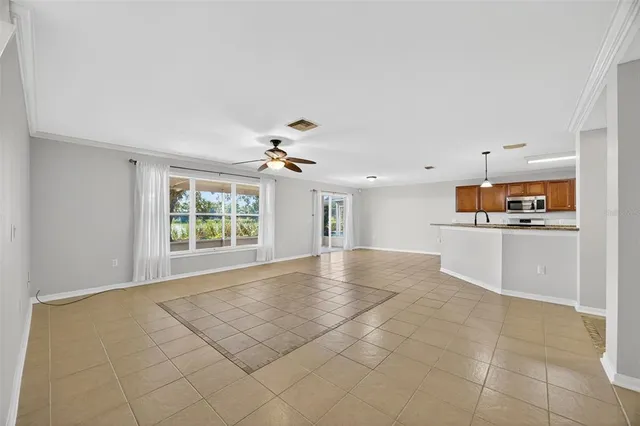 a view of a livingroom with a ceiling fan a kitchen space and a sink