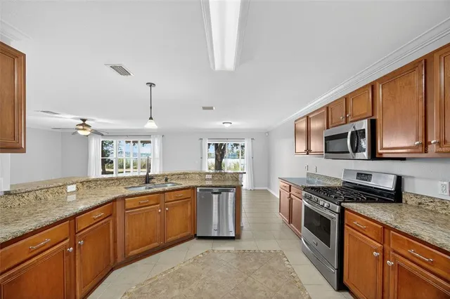 a kitchen with granite countertop stainless steel appliances a stove sink and microwave