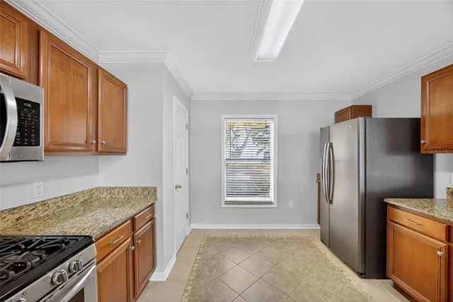 a kitchen with stainless steel appliances granite countertop a sink a stove top oven a counter space and cabinets