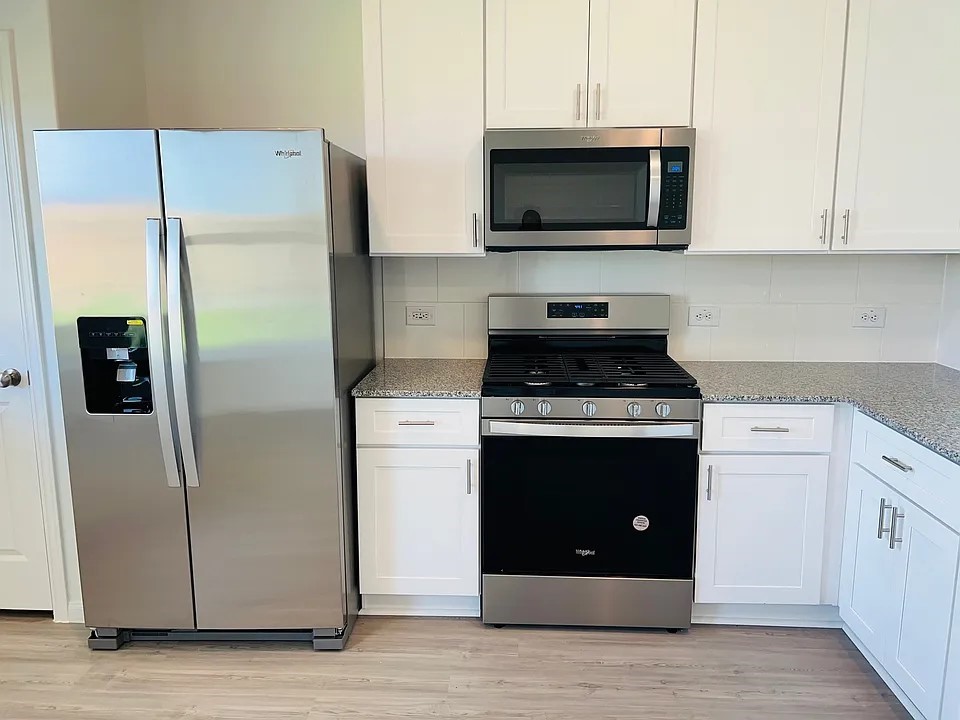 a stove top oven sitting inside of a kitchen