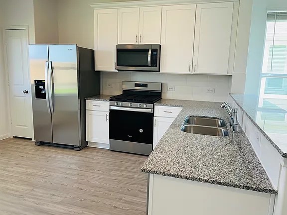 23422 Weir Box Road Hockley, TX 77447 - Photo 4 of 14 a kitchen with stainless steel appliances granite countertop a stove a refrigerator and a sink
