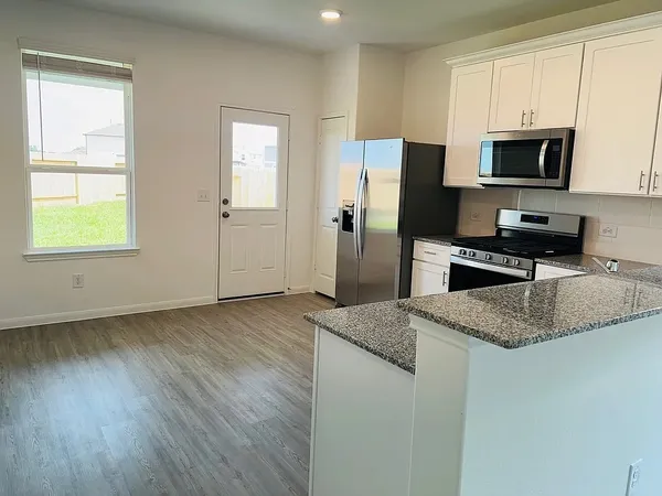 a kitchen with stainless steel appliances granite countertop a stove a sink and a microwave