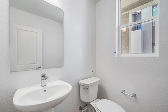 a bathroom with a sink mirror and toilet