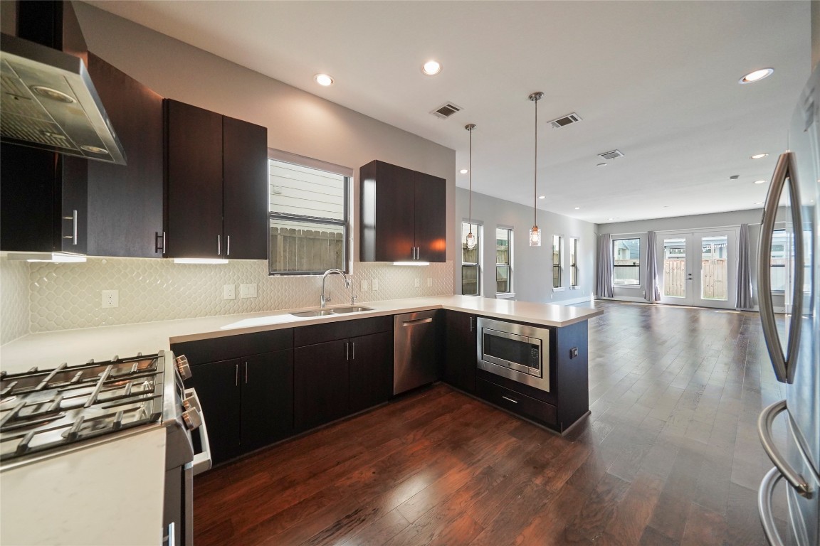 4123 Eigel Street Houston, TX 77007 - Photo 10 of 25 a large kitchen with stainless steel appliances kitchen island granite countertop a stove a sink and a microwave