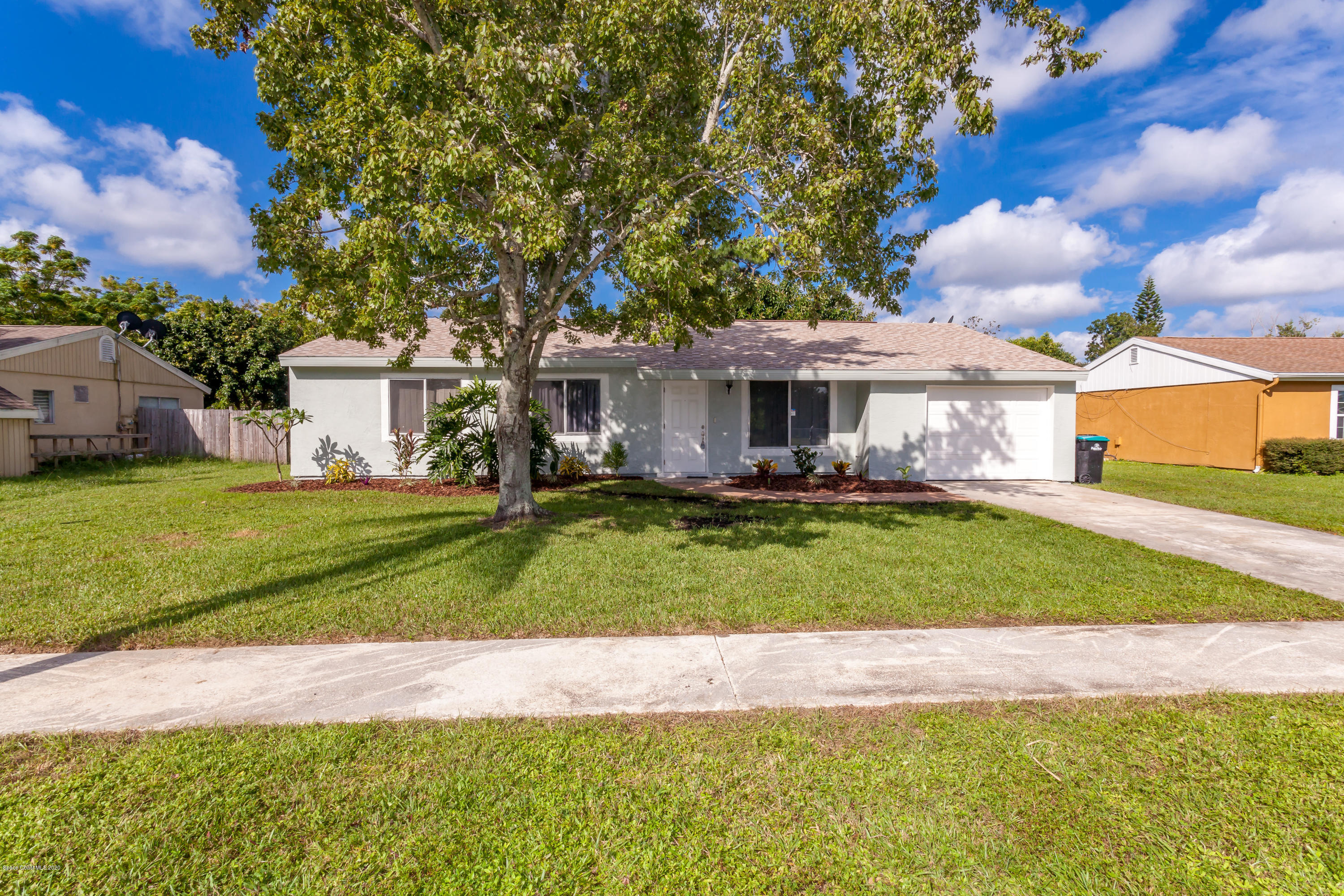 1280 Freil Road Northeast Palm Bay, FL 32905 - Photo 1 of 15 a front view of a house with a yard table and chairs
