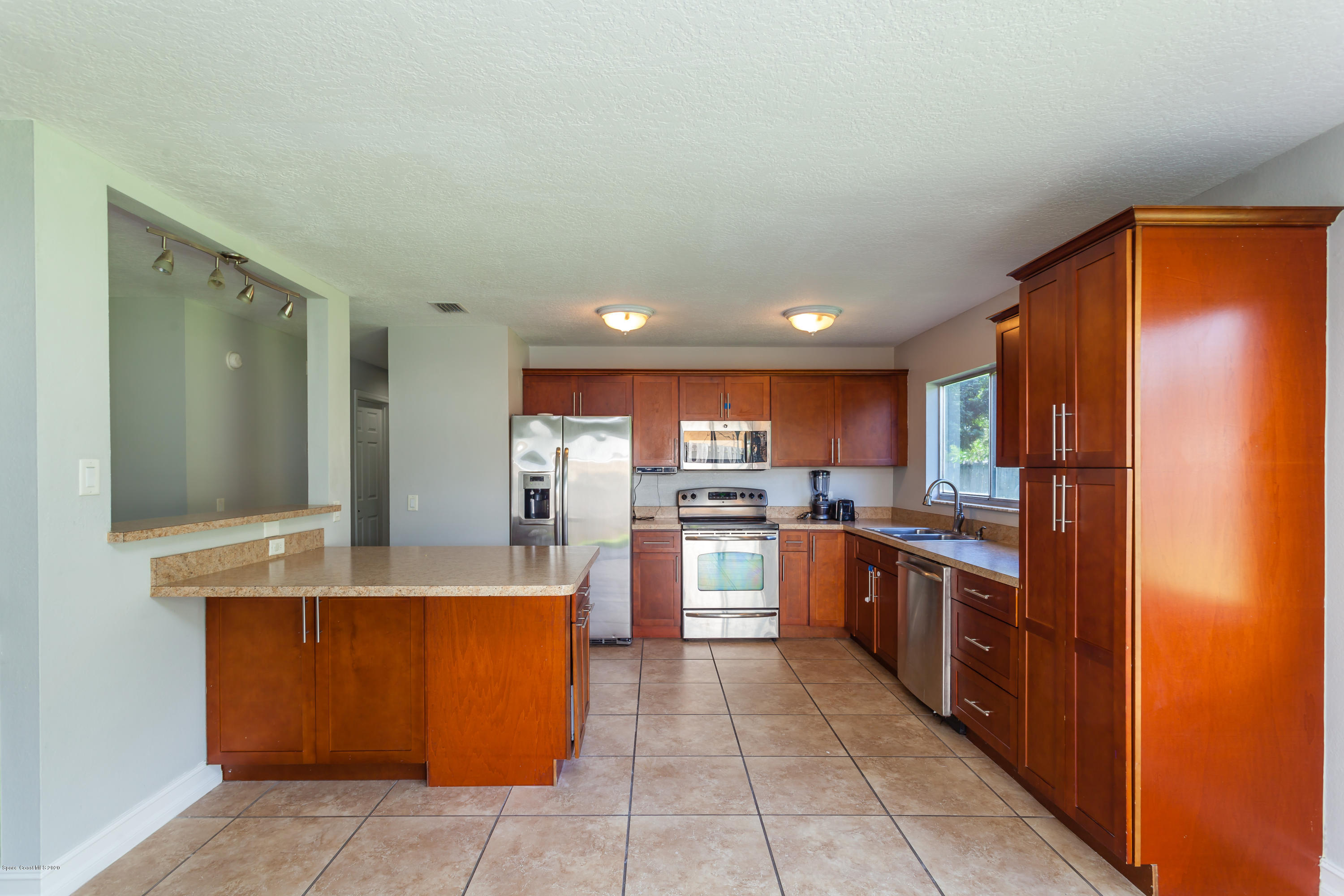 1280 Freil Road Northeast Palm Bay, FL 32905 - Photo 8 of 15 a large kitchen with stainless steel appliances granite countertop a refrigerator and a stove