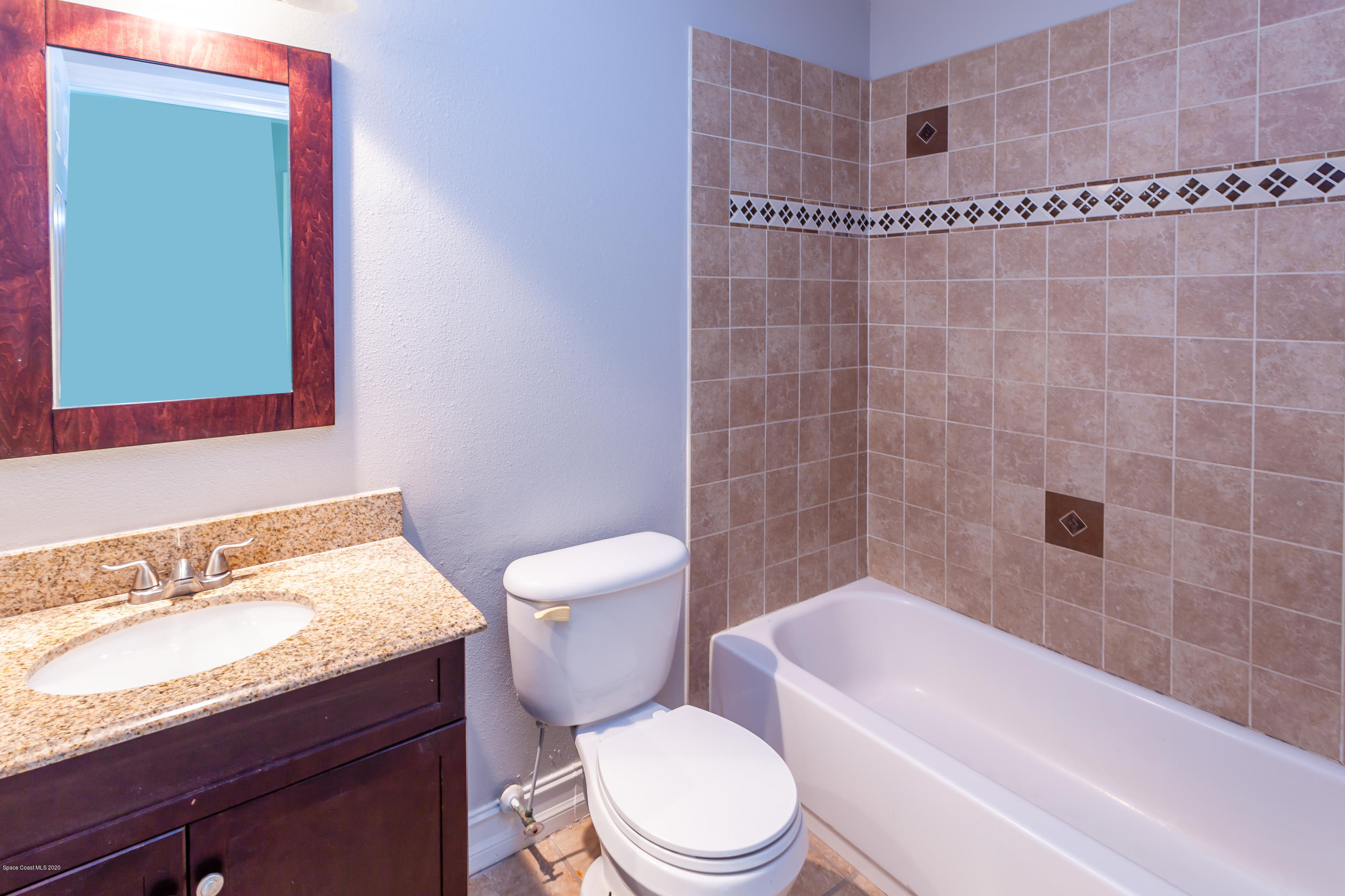 1280 Freil Road Northeast Palm Bay, FL 32905 - Photo 10 of 15 a white toilet sitting next to a bath tub and a sink