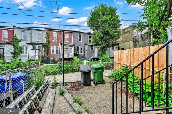 a view of a house with a small yard and wooden fence