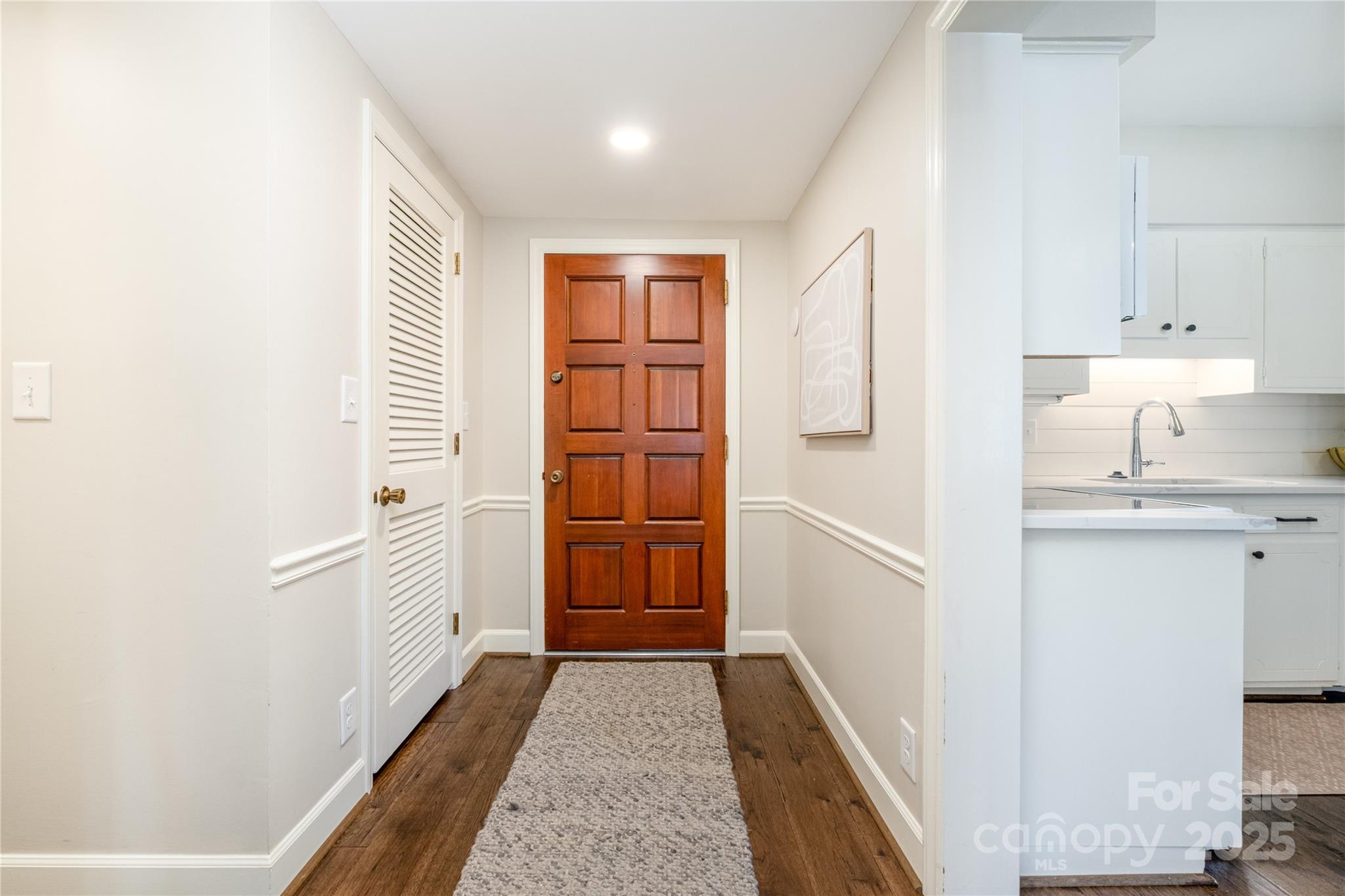 4527 Gaynor Road, Unit 303 Charlotte, NC 28211 - Photo 4 of 28 a hallway with white cabinets and wooden floor