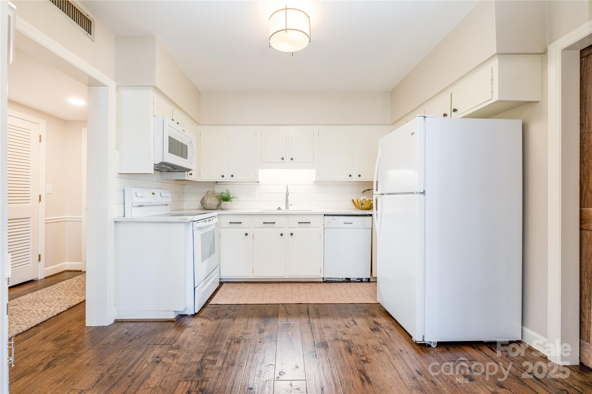 4527 Gaynor Road, Unit 303 Charlotte, NC 28211 - Photo 6 of 28 a kitchen with a refrigerator a white stove top oven and white cabinets